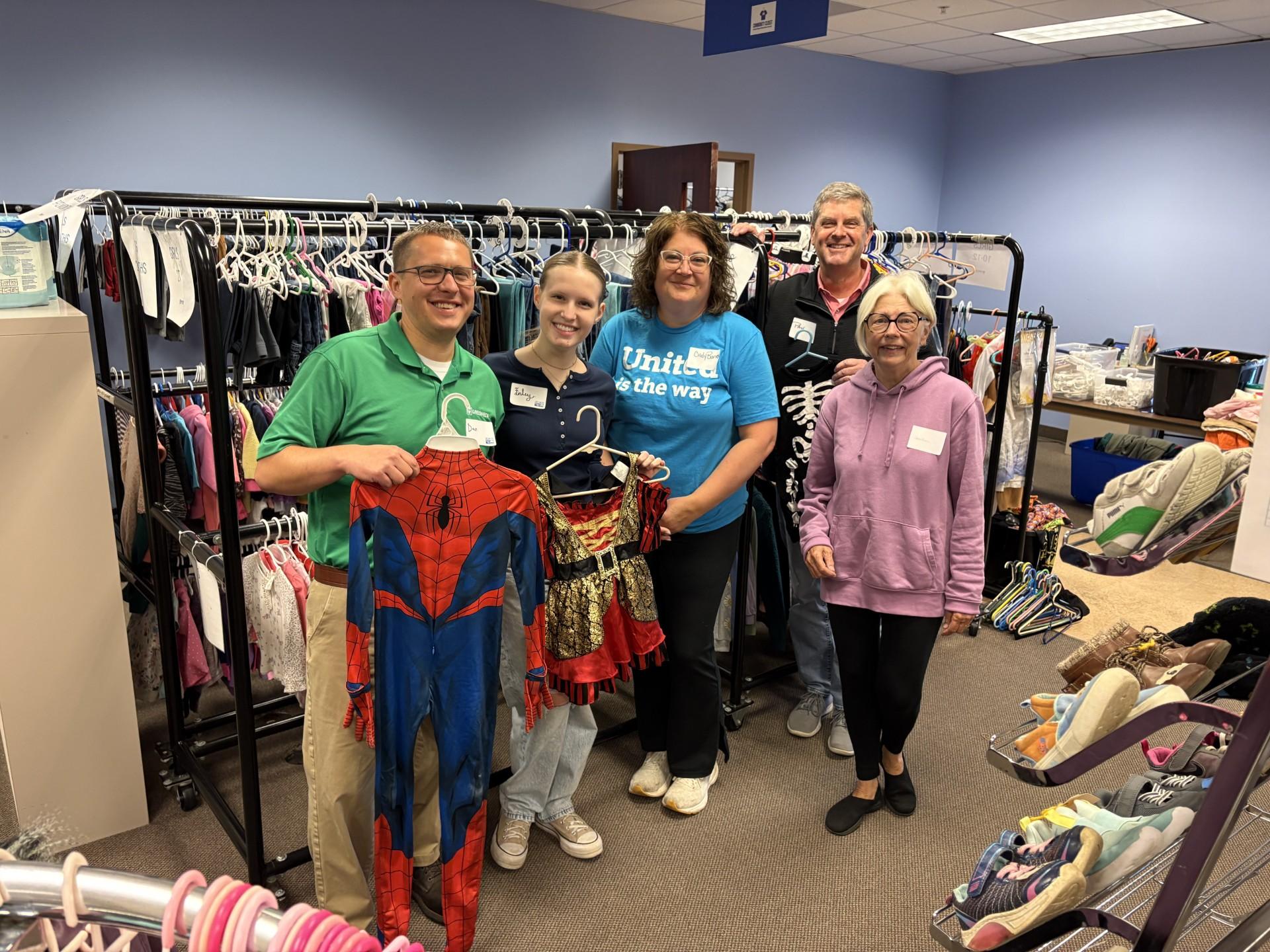 People standing in front of a clothes rack.