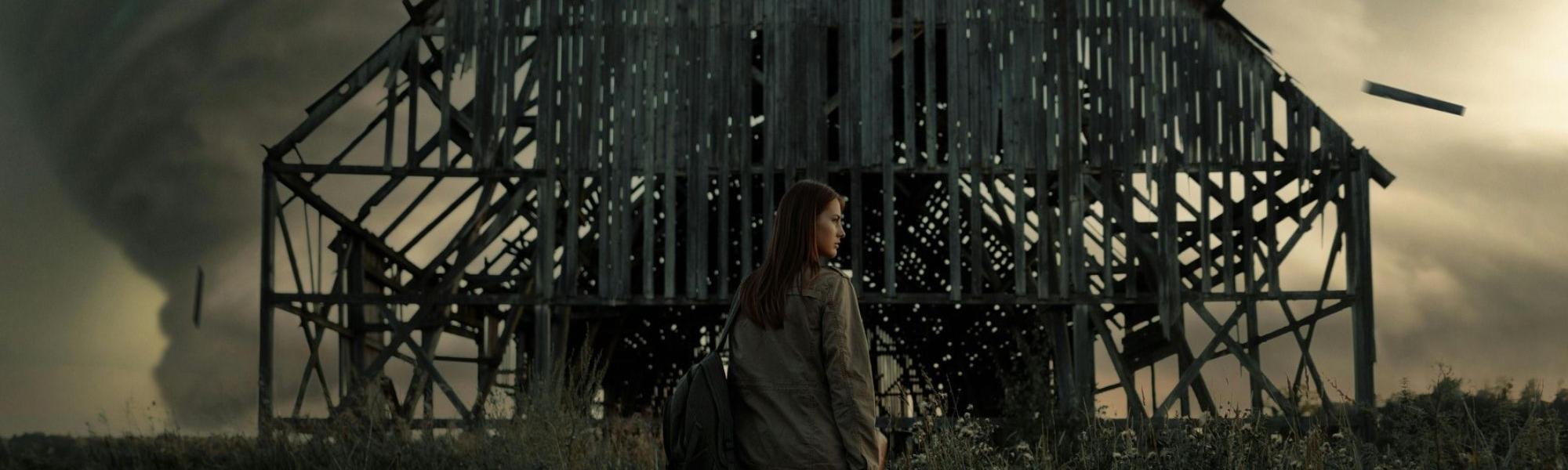 Woman standing in front of a dilapidated barn